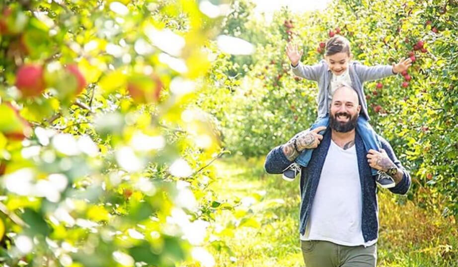 Dad and daughter in apple orchard