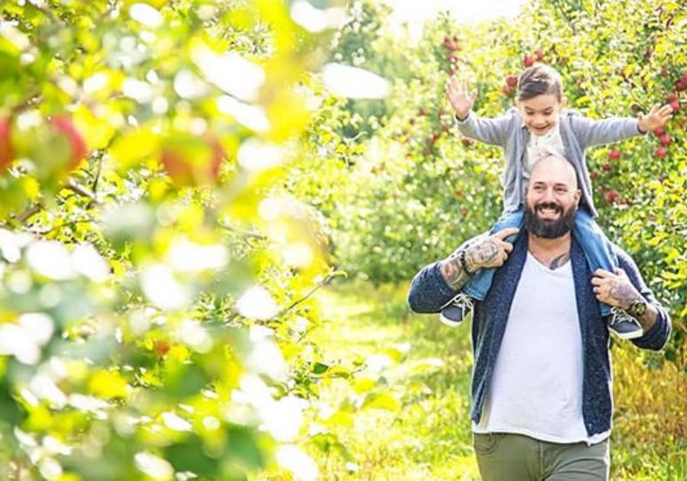 Dad and daughter in apple orchard